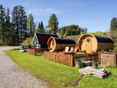 Schlafhütte und Fässer am Campingplatz Gelände